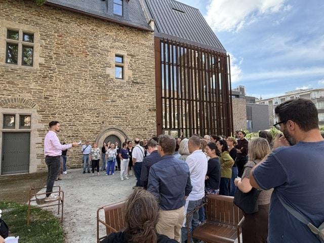 Participants rassemblés dans la cour d'un bâtiment historique pour un jeu d'enquête